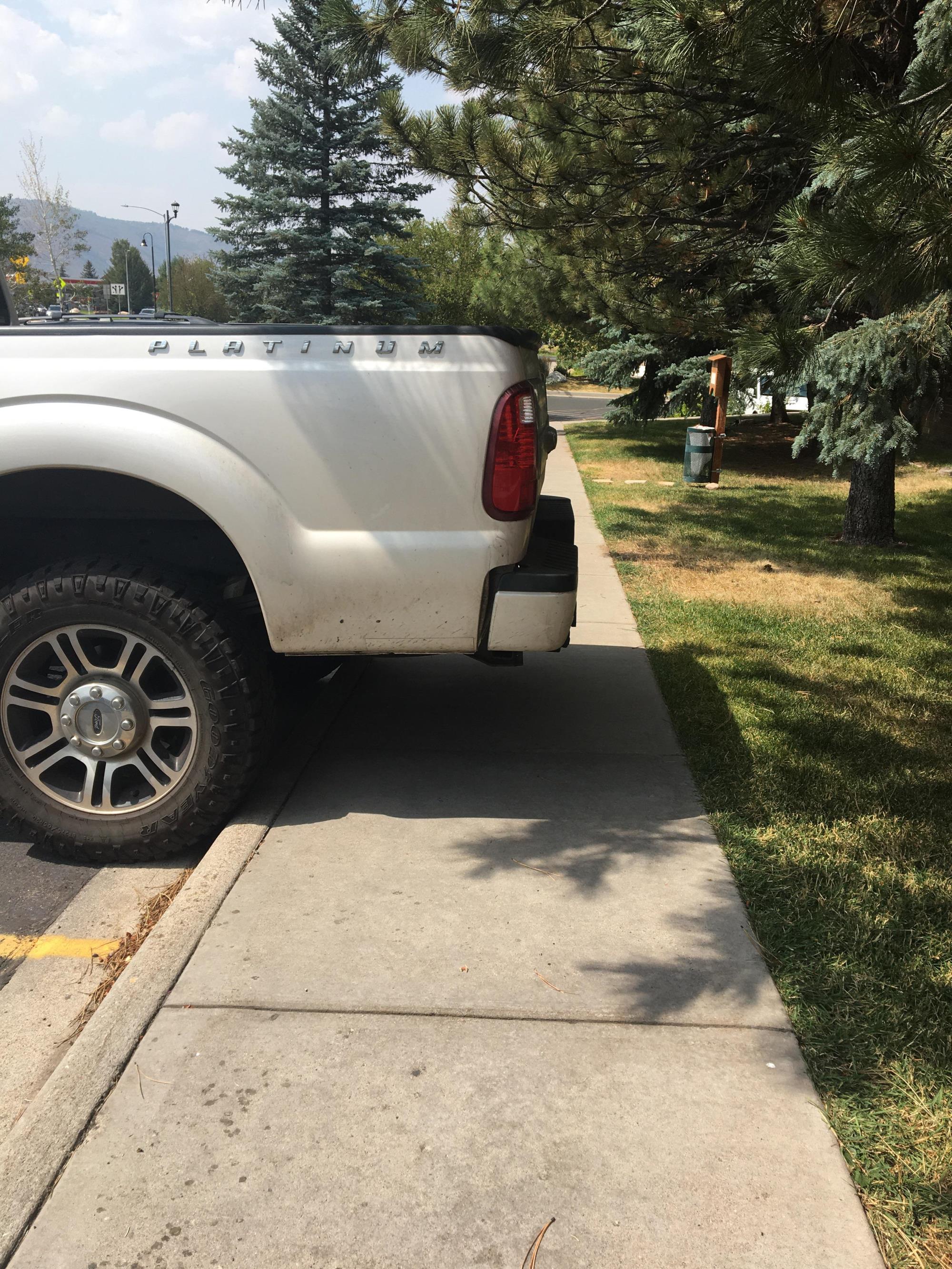 the rear of the truck blocking part of a sidewalk